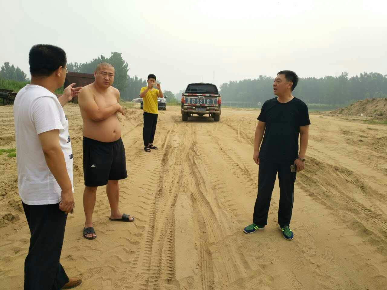 宋景立在烈日下耐心给砂场场主解释政策.jpg